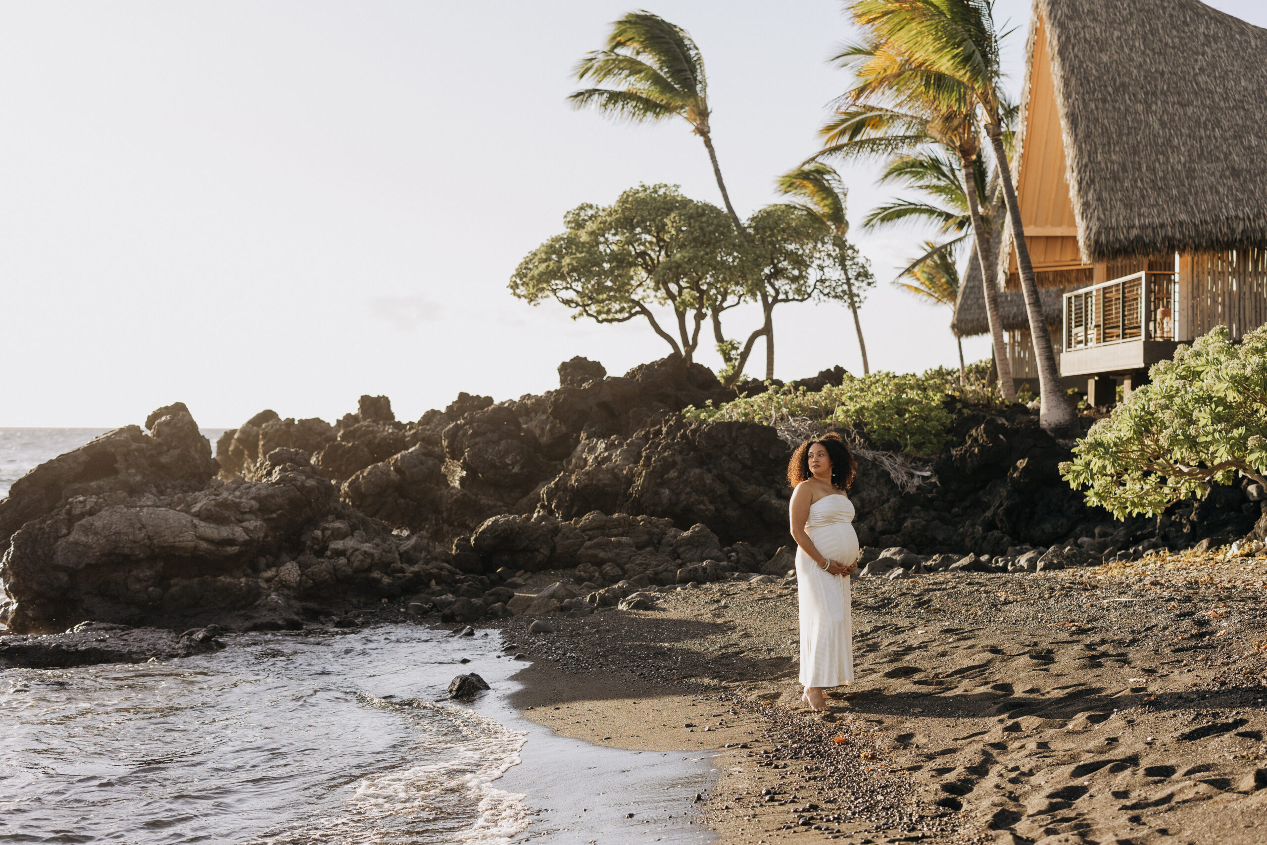 A serene moment for the mother-to-be, framed by the historic hale at Kona Village, A Rosewood Resort.